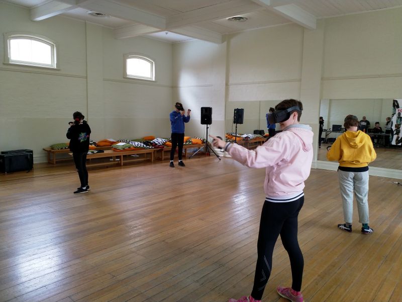 Four students with Oculus Quest headsets taking part in a theatrical experience