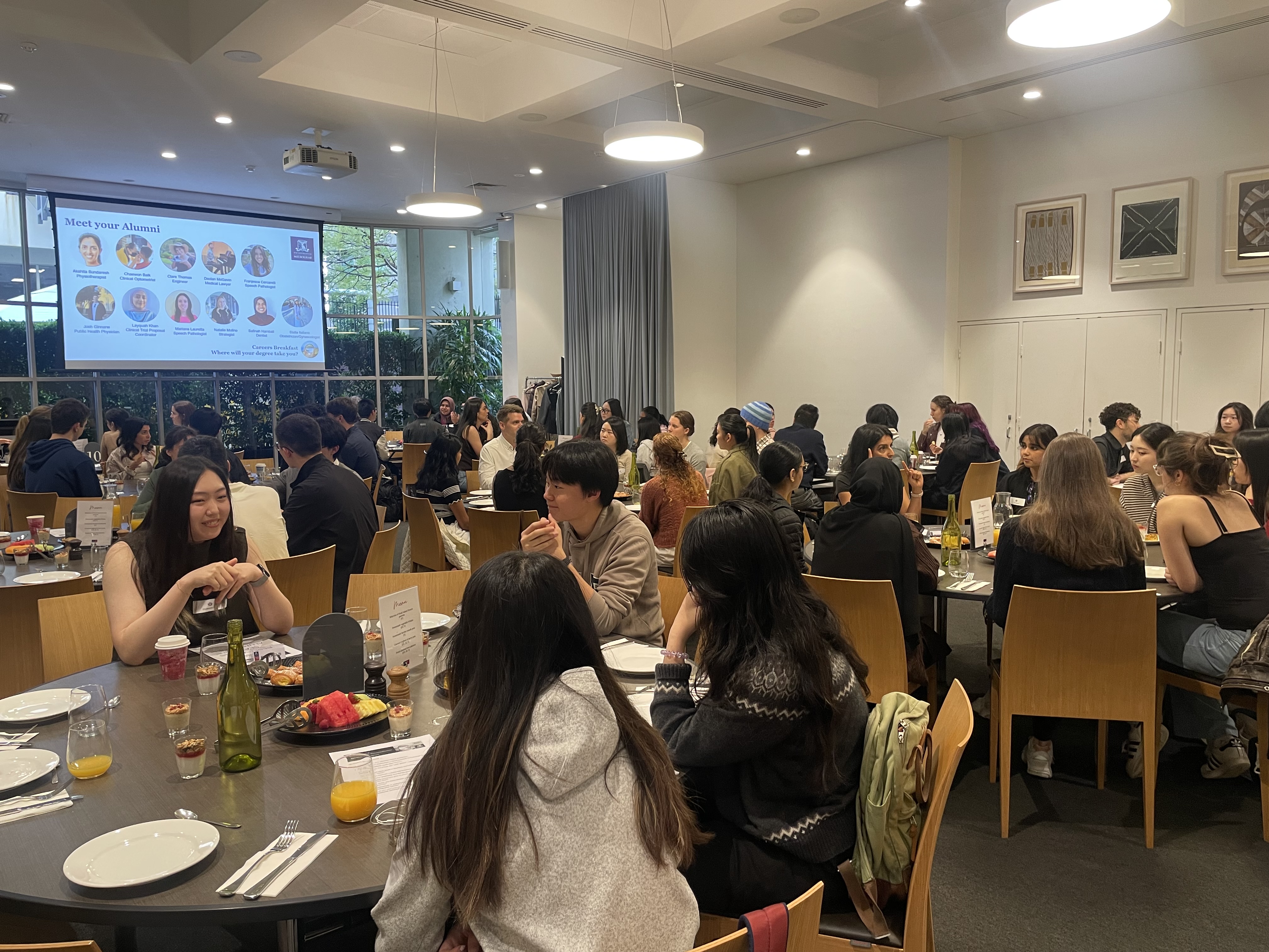 students at indoor function at tables