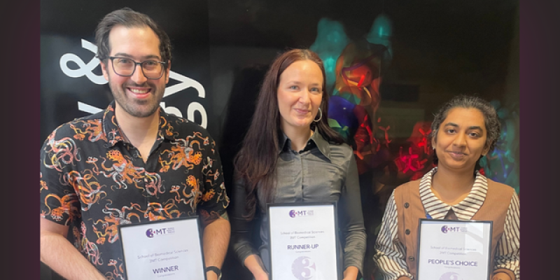 three people stand with framed certificates